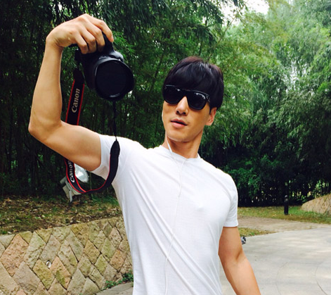 张亮在微博晒出靓照,照片中他戴着太阳镜手拿单反拍照,摆pose帅垦难